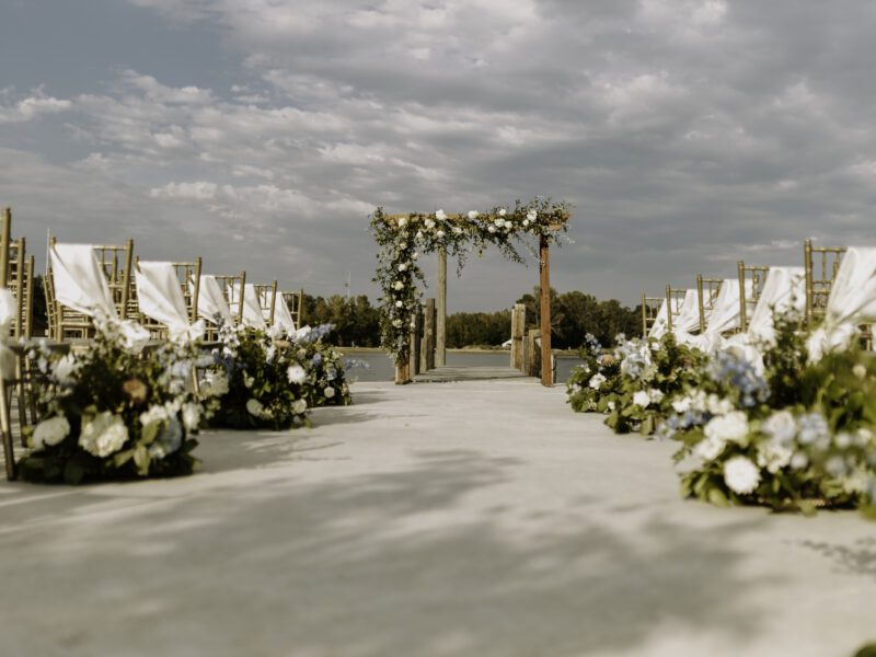 summer wedding ceremony with blue, peach, and white florals