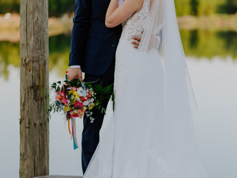 Lakeside wedding ceremony at C&C by the Lake, offering breathtaking views and vibrant summer floral decor