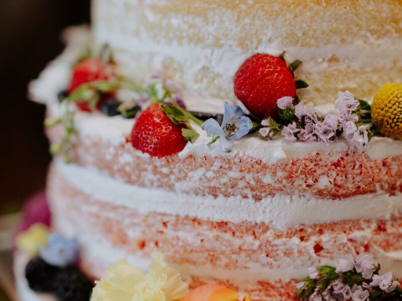 Summer wedding cake with colorful floral accents at C&C by the Lake, designed to match the vibrant theme of the celebration.